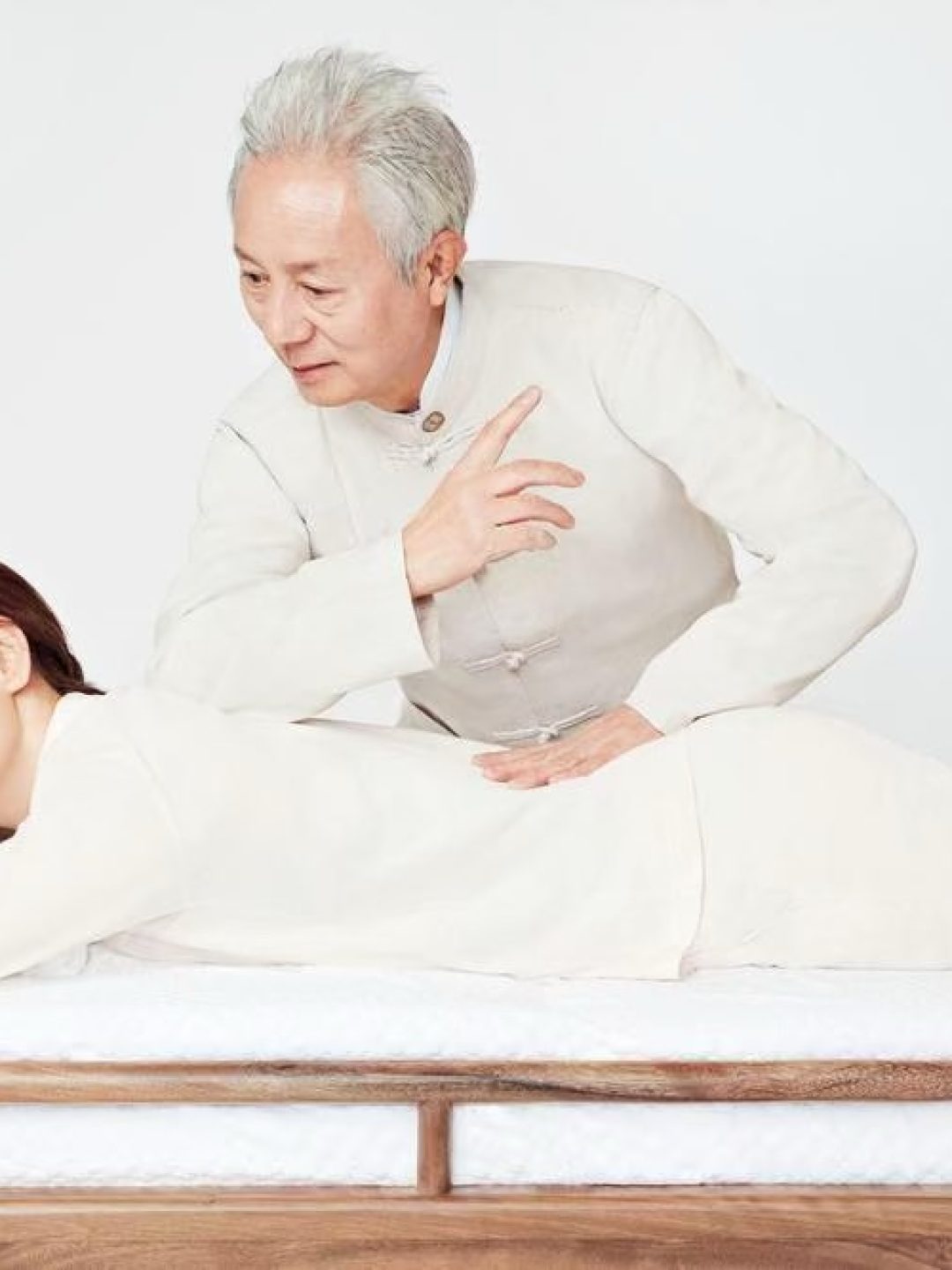 A Tuina practitioner demonstrating traditional full-body massage techniques used for therapeutic alignment.