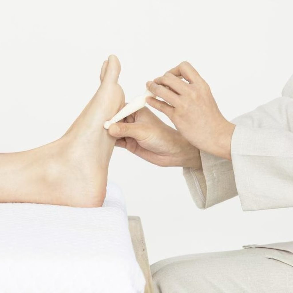 Foot acupressure massage targeting pressure points to improve circulation and relaxation.