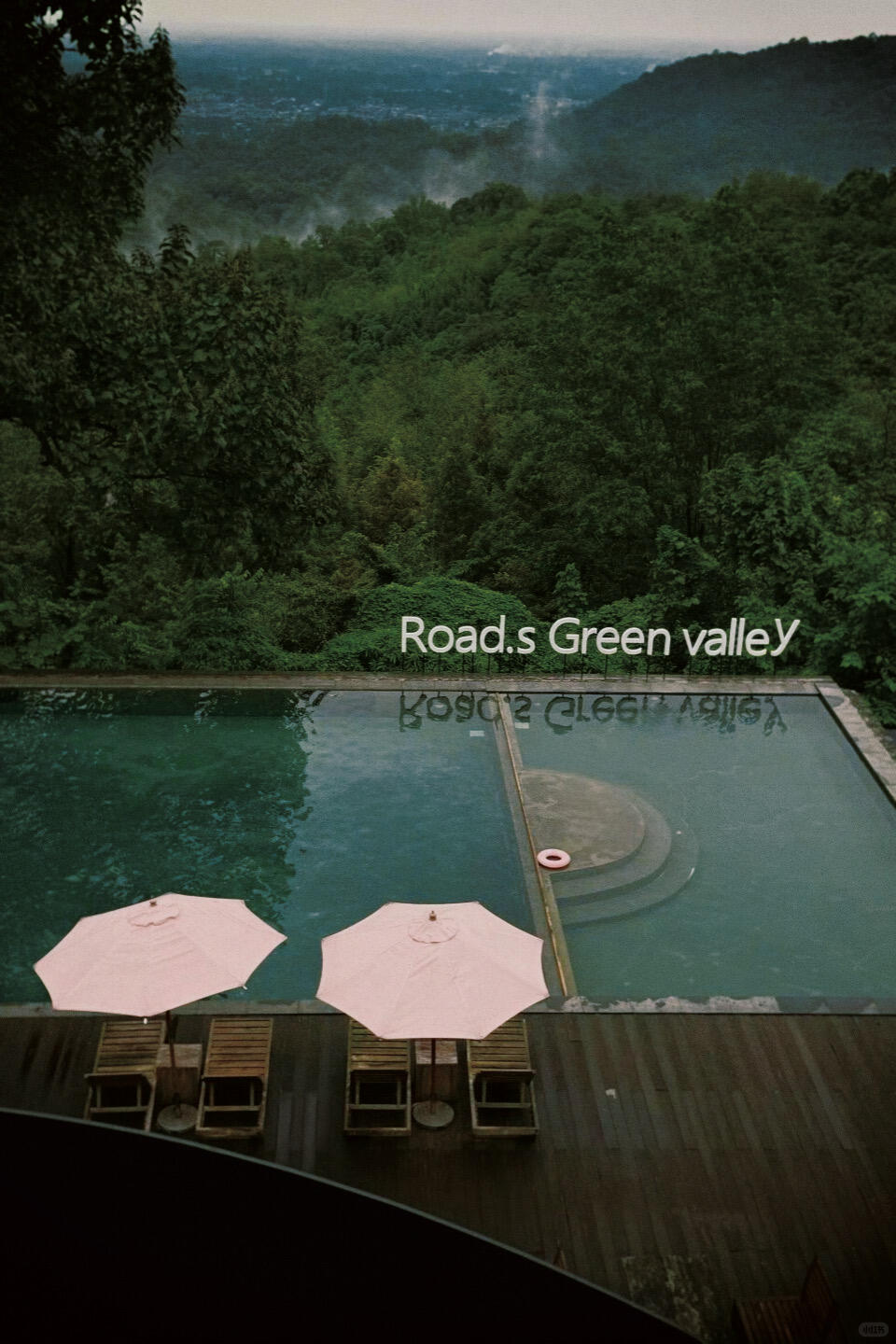 Aerial view of the forest-covered valley and the mountain-facing pool area at Lu Zhi Green Valley.
