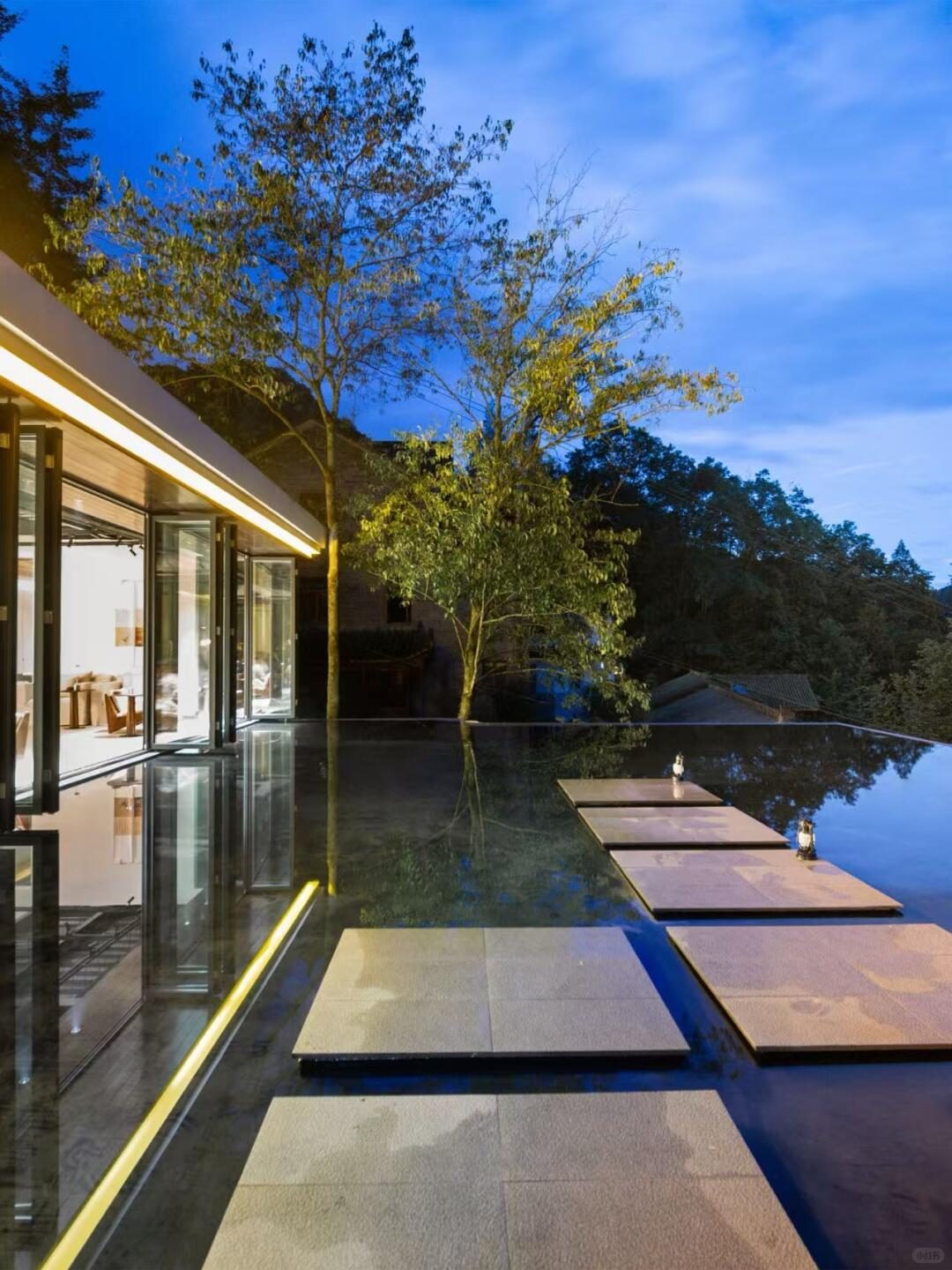 Infinity-style water terrace reflecting the surrounding trees and mountain views at Wangshan Xiyue Shan.