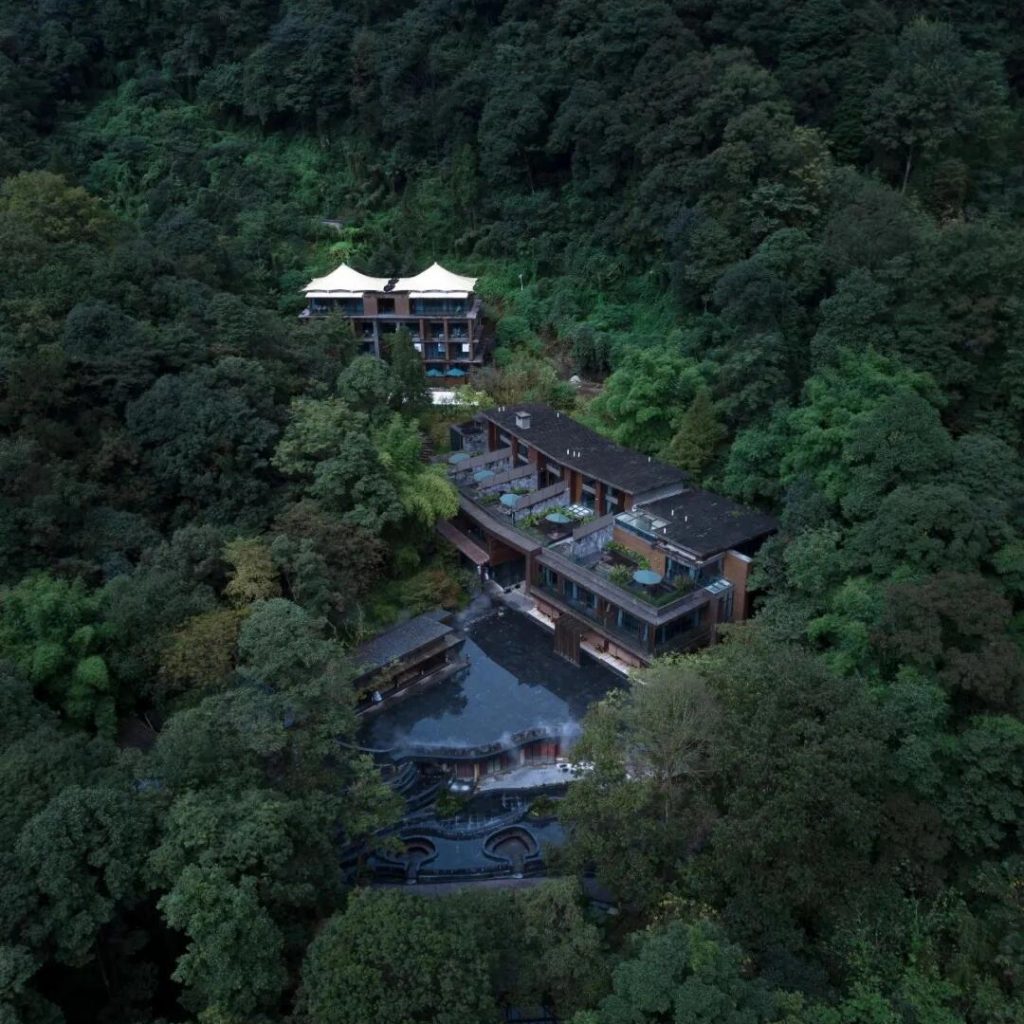 Aerial view of Zuwang Forest Hotel surrounded by dense mountain forests, showcasing its quiet, Zen-inspired retreat setting.